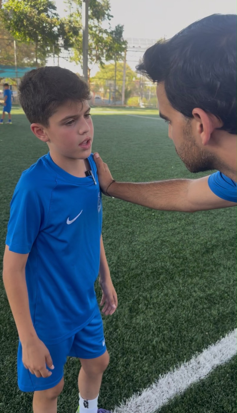 איתי טאוב מדבר עם ילד בגובה העיניים במגרש